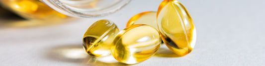 Close-up of transparent golden omega-3 fish oil softgel capsules